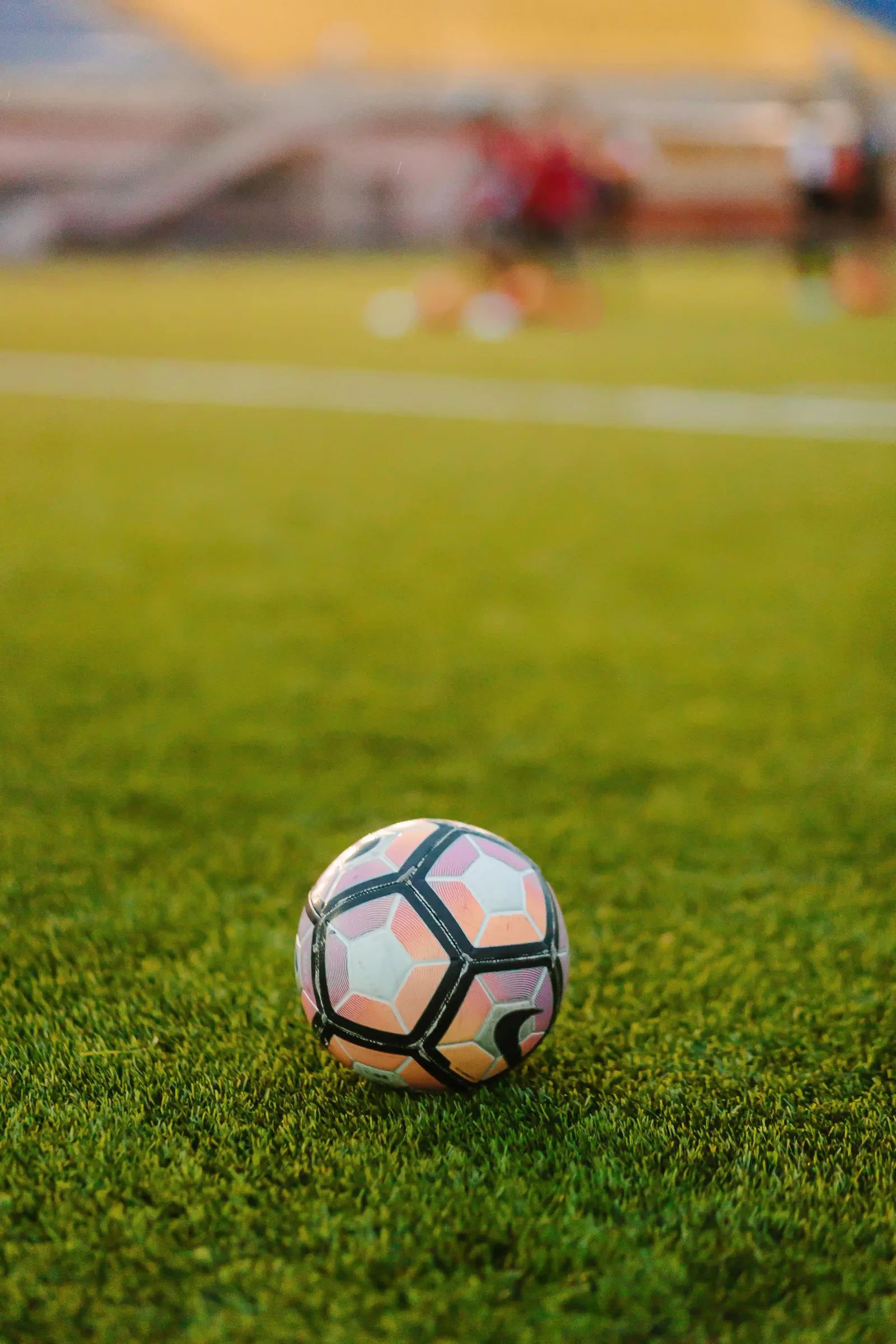 Ballon de football posé sur un terrain en gazon synthétique